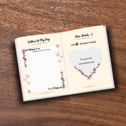 Opened decorated pet memorial journal showing customizable pages on a wooden table