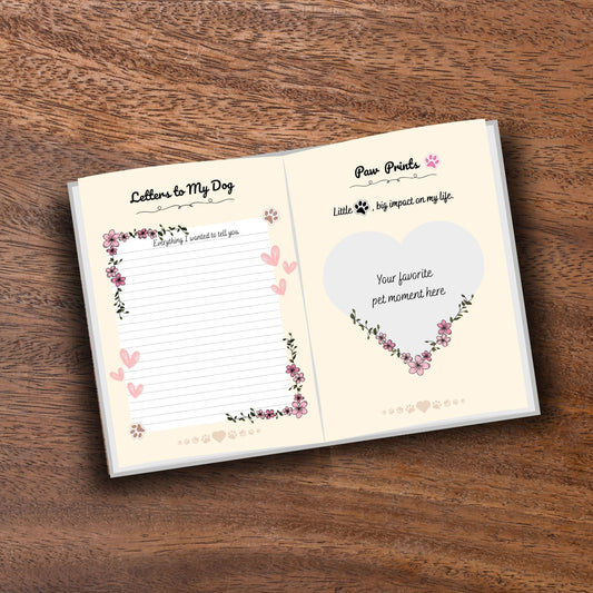 Opened decorated pet memorial journal showing customizable pages on a wooden table